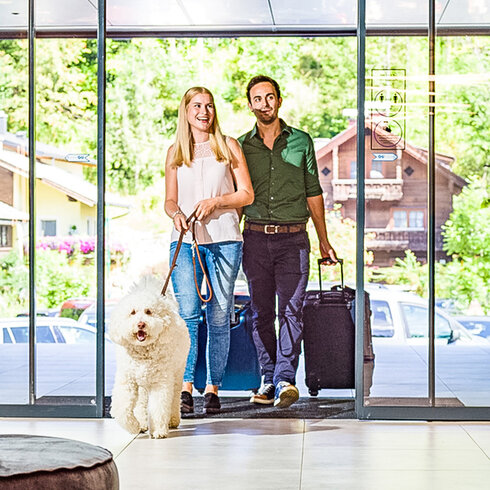 Paar mit weißem Hund in der Hotellobby